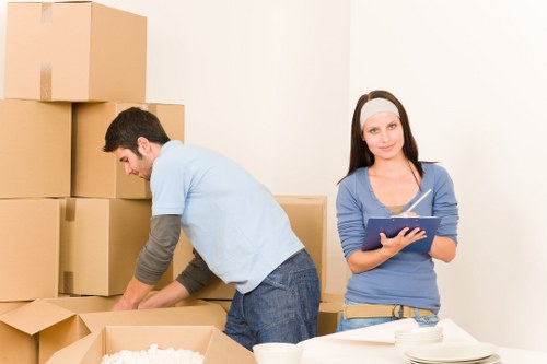Movers carrying furniture near apartment buildings in Wimbledon
